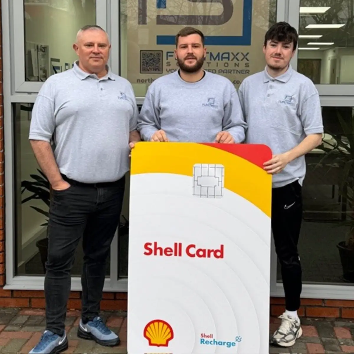 Alex wood holding a giant Shell Recharge Card with the Northwich team