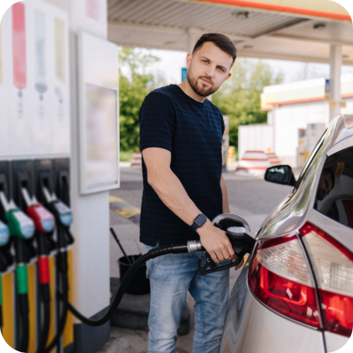 Fuel Card Vs Credit Card: Business driver refuelling a company car at a fuel station, highlighting fuel card and company credit card fuel purchases.