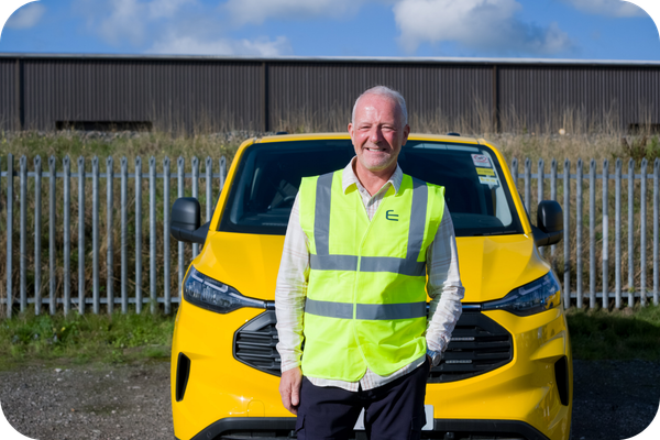 Fleetmaxx Solutions vehicle movement specialist standing in front of a yellow commercial vehicle providing nationwide vehicle delivery and fleet movement services.