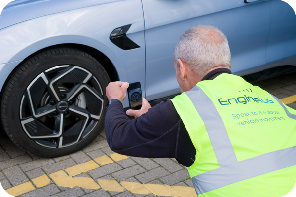 Vehicle movement specialist carrying out a digital vehicle inspection and condition report before vehicle collection or delivery.