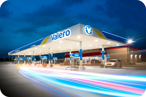 Modern Valero service station illuminated at night, highlighting the growing Valero fuel station network available to Texaco Fastfuel fuel card customers across the UK.