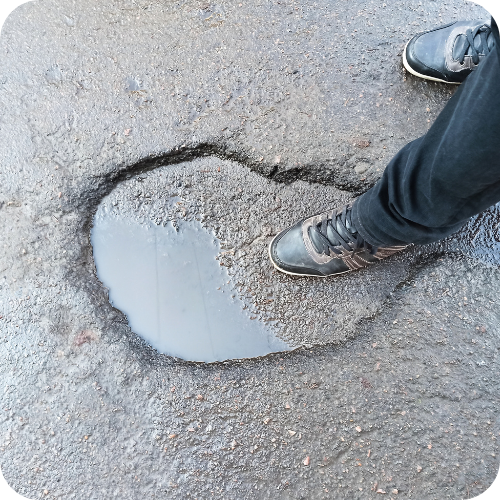 Pothole damage - Deep water-filled pothole that could cause tyre, wheel and suspension damage