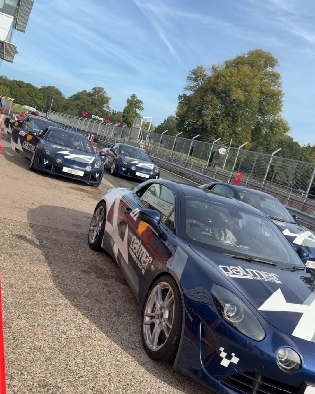 Alpine A110 sports cars lined up at Oulton Park for a track day attended by the Fleetmaxx team